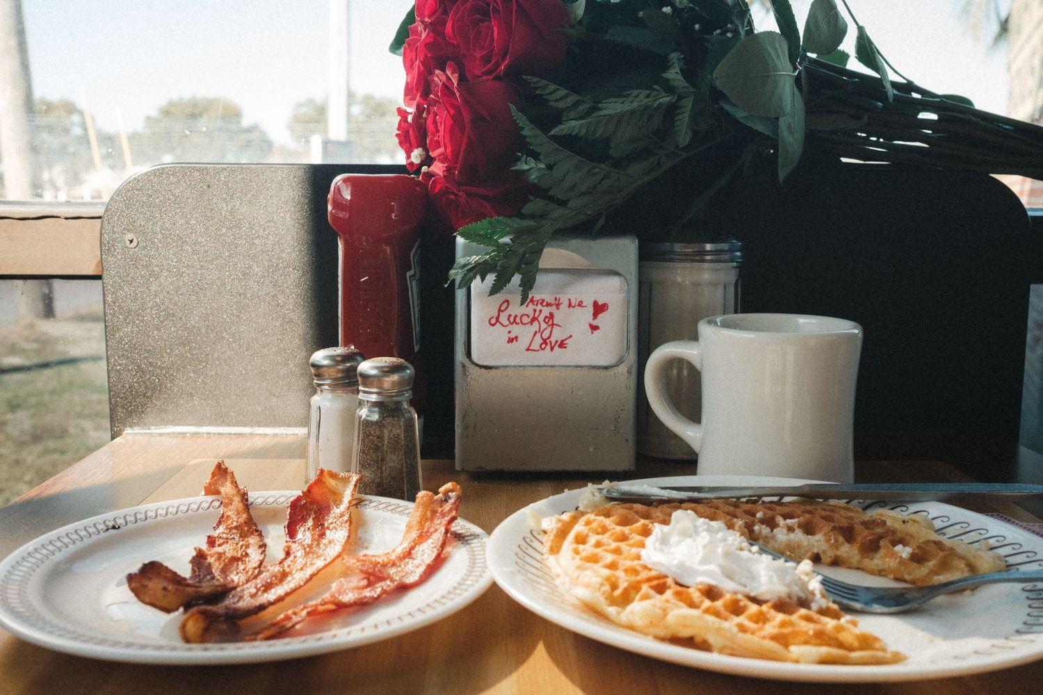 Breakfast table setting with waffles and coffee in a cozy cafe atmosphere.