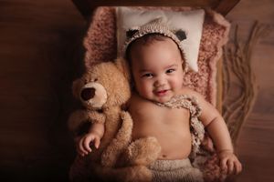Baby laying holding. teddy bears stuffed animal