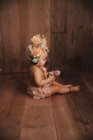 toddler wearing flower bonnet sitting in Portland studio photoshoot