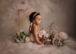 Baby sitting on floor with flowers for sitter photo session