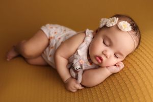 Baby laying on side with hand on face