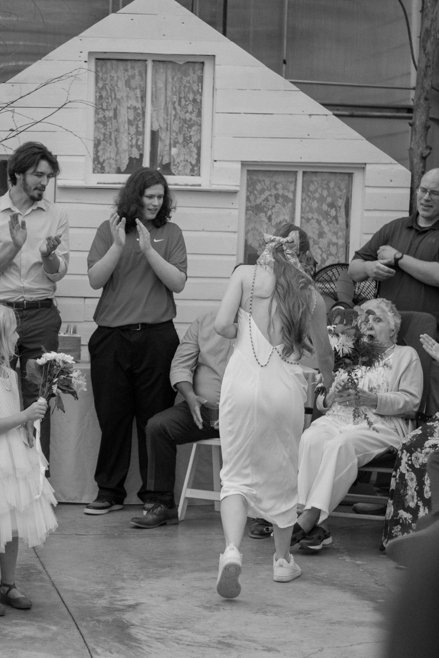 A heartwarming black and white photo showing joyful moments shared between two generations on a brick patio.