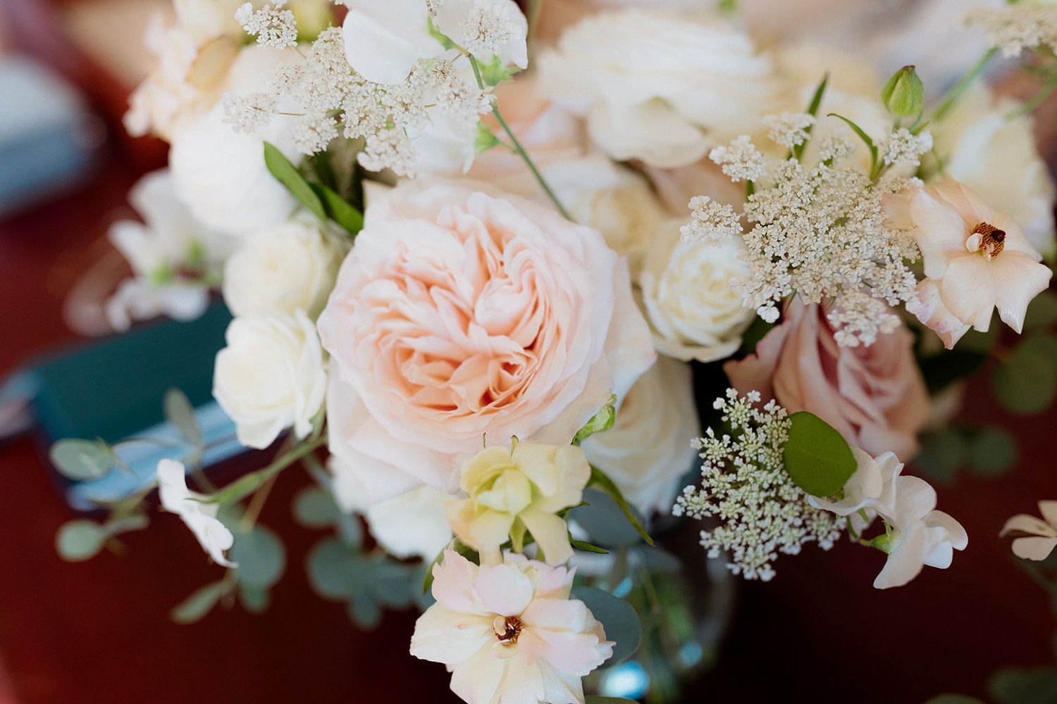 Delicate white and blush pink floral arrangements with roses and greenery create an elegant wedding display.