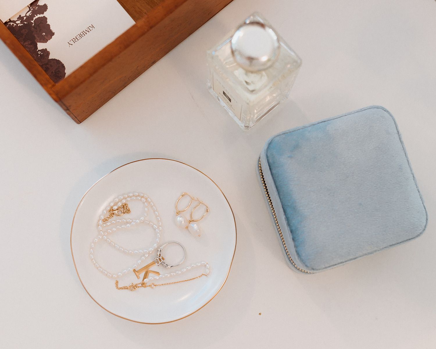 Wedding reception details with delicate blue and gold place settings on wooden tables.