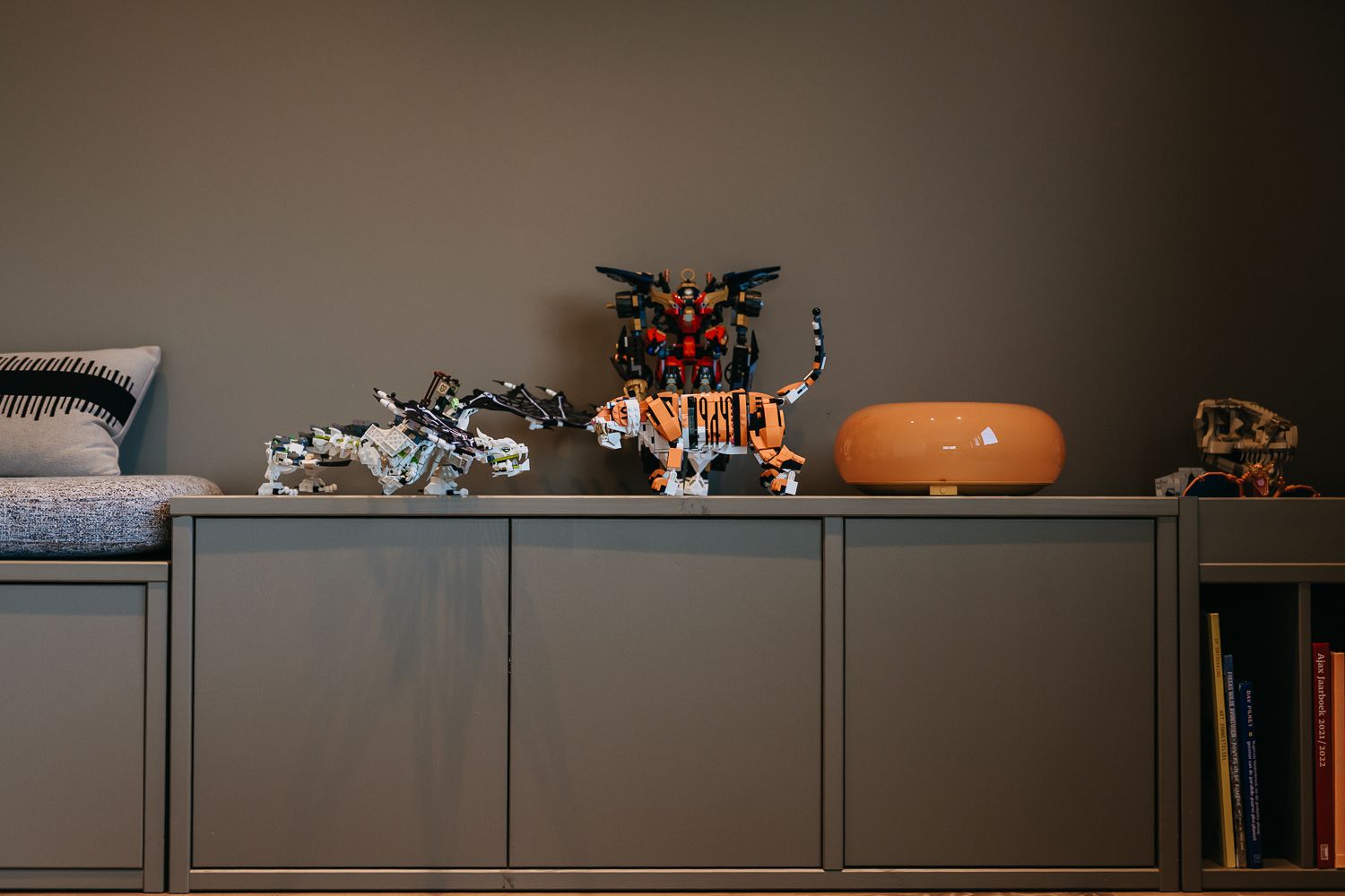 Overzicht van tienerkamer met Woood kast, opgeruimd speelgoed en Lego-opslag. Voetbal helden aan de muur in lijsten.