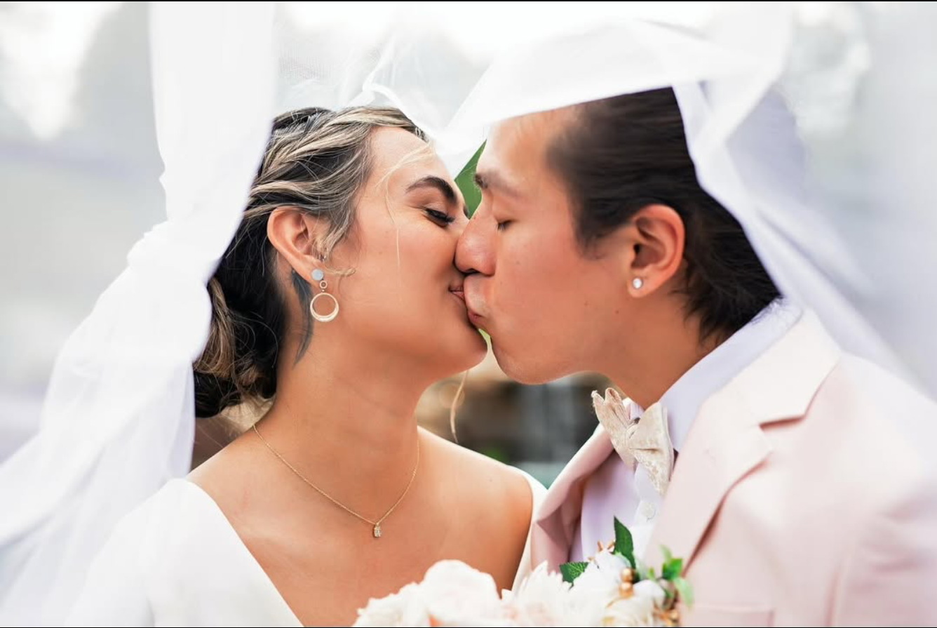 Intimate wedding moment captured in soft natural lighting with floral details.
