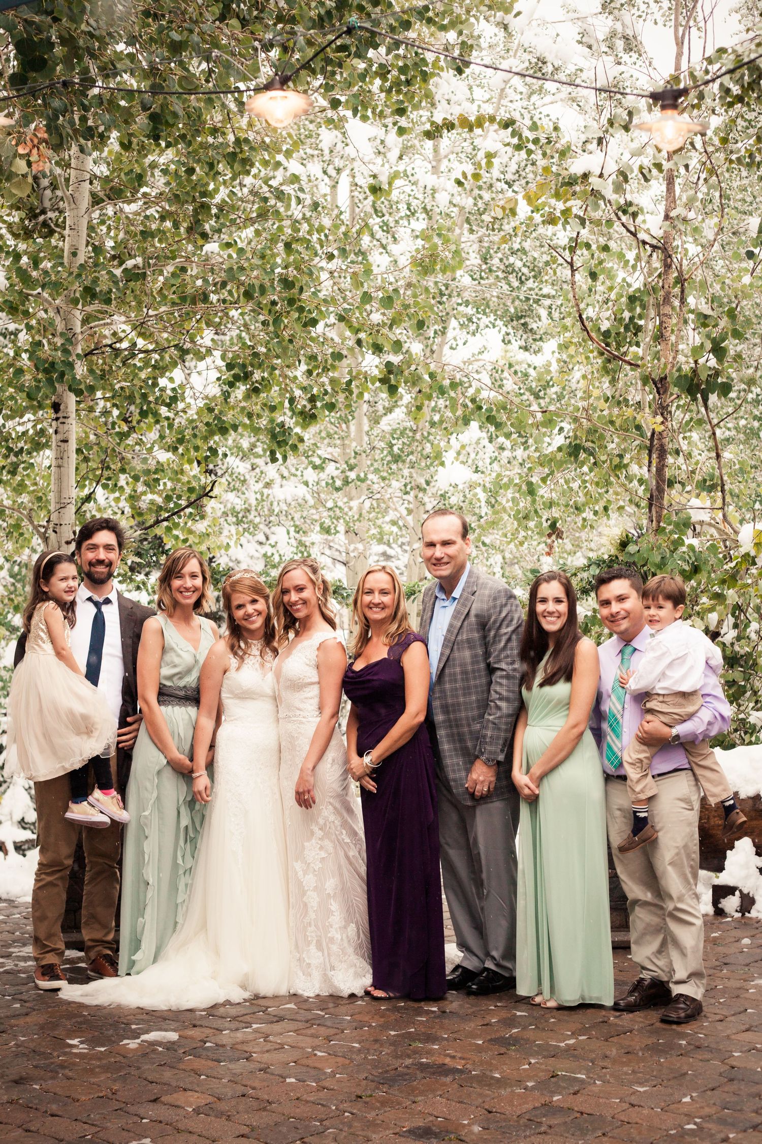 Wedding party poses for a group photo outdoors with bridesmaids in mint green dresses.