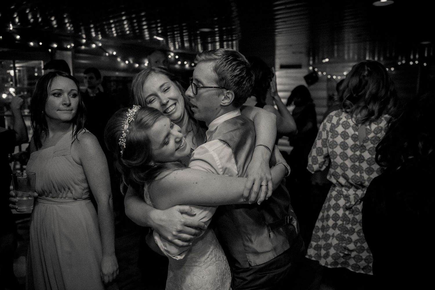 People embracing and celebrating during a party in an intimate black and white moment.