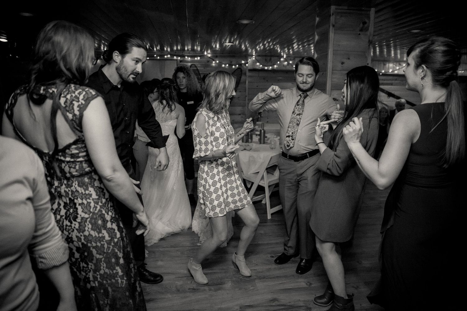 People dancing and having fun at a lively indoor party in black and white photography.
