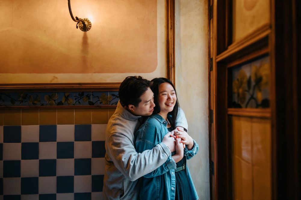 Detail of the couple’s hands intertwined against Gaudí’s patterned tiles.