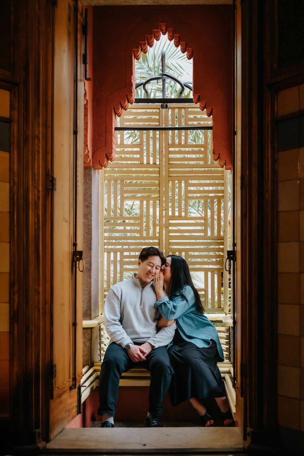Elegant portrait of the couple standing close with Casa Vicens textures behind.