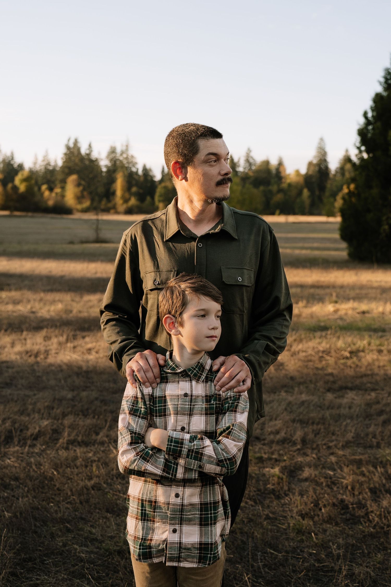 Intimate outdoor portrait session showing tender family moments in a rustic field setting.