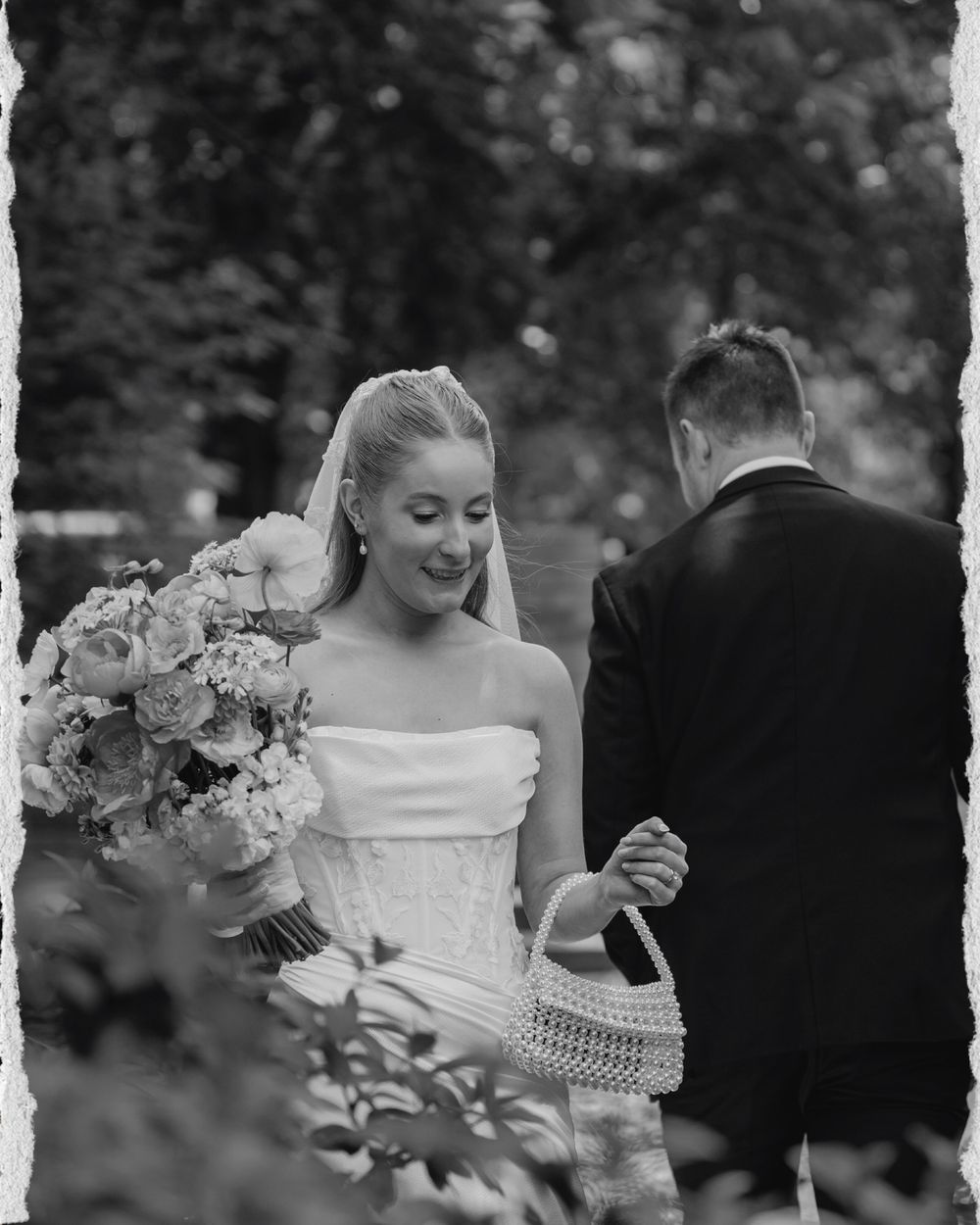 An elegant outdoor wedding celebration with white flowers and formal attire in a garden setting.