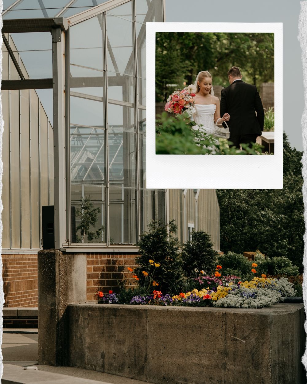 Glass greenhouse exterior with brick walls and colorful flower gardens along the entrance pathway.