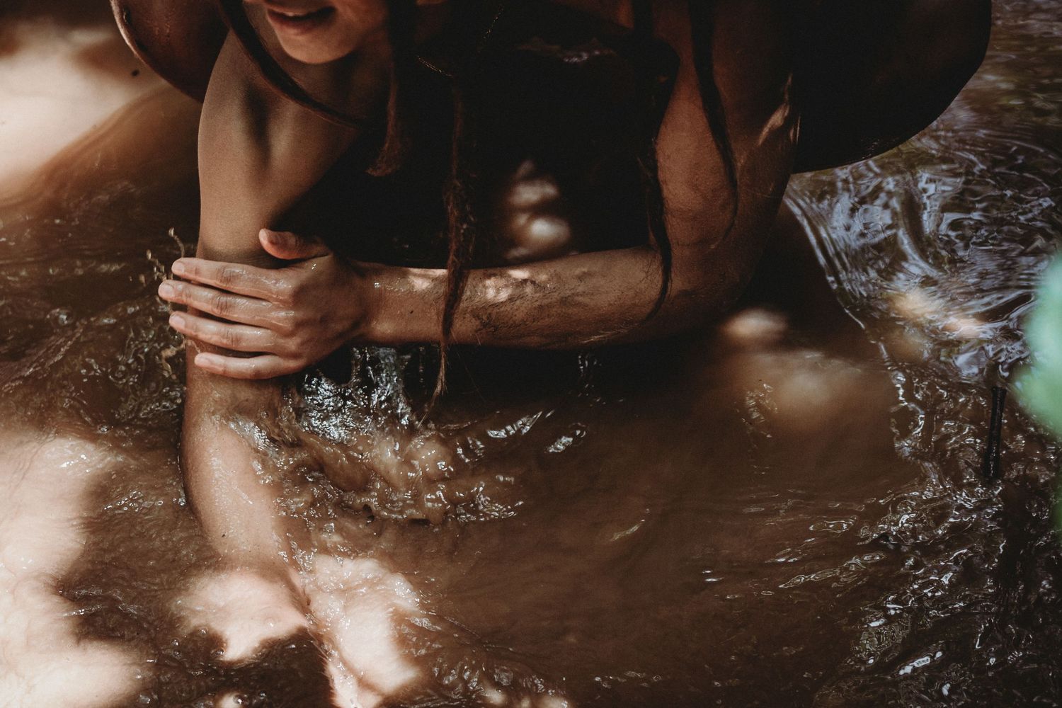 Mulher nua em sessão fotográfica feminina na natureza foto colorida com braços na agua em momento de coneXão com a natureza em Alcobaça