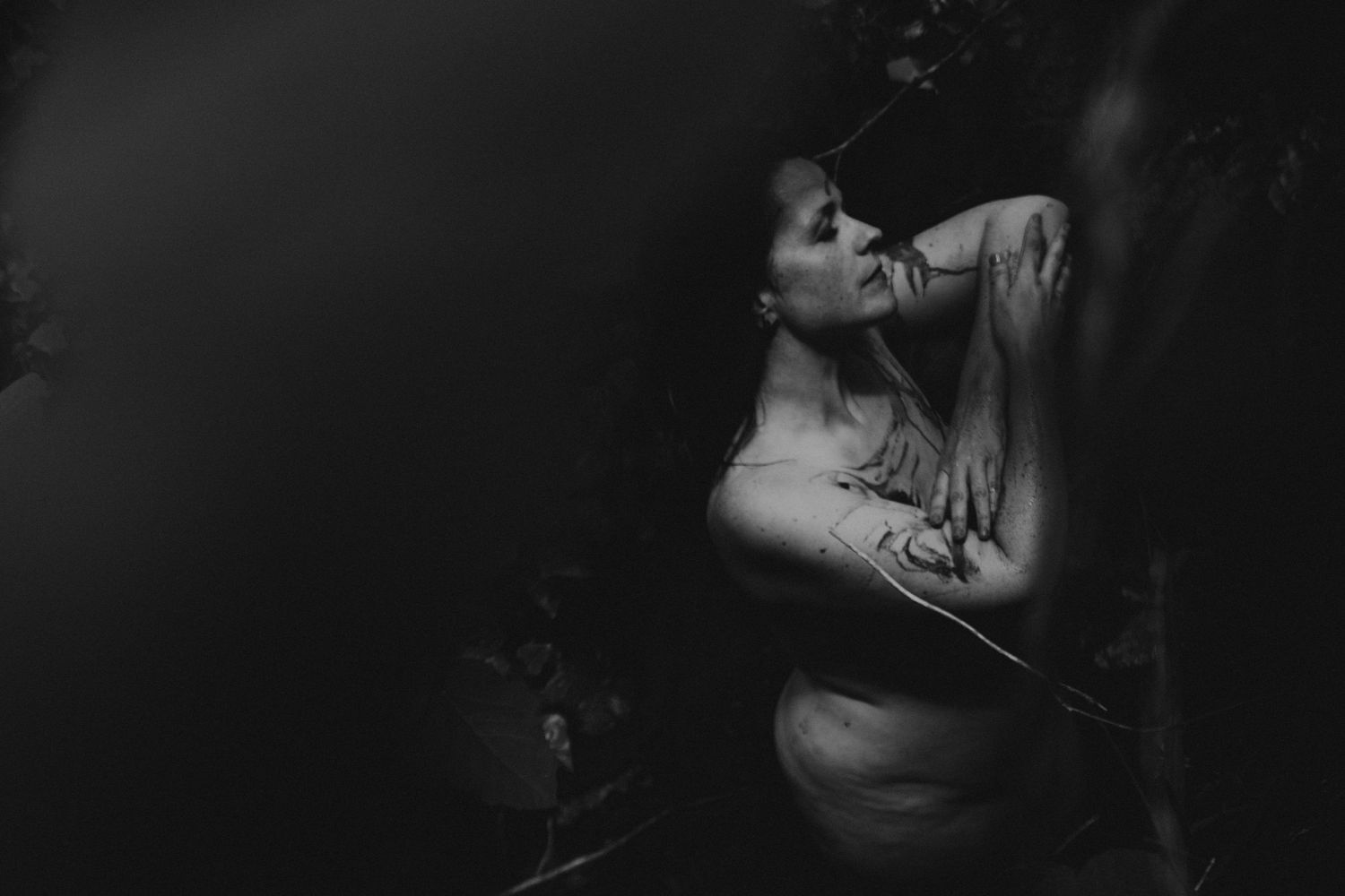 Mulher em ritual da lama em uma foto preto e branco com luz central ,  numa sessão feminina de rituais em Caldas Da Rainha Portugal.