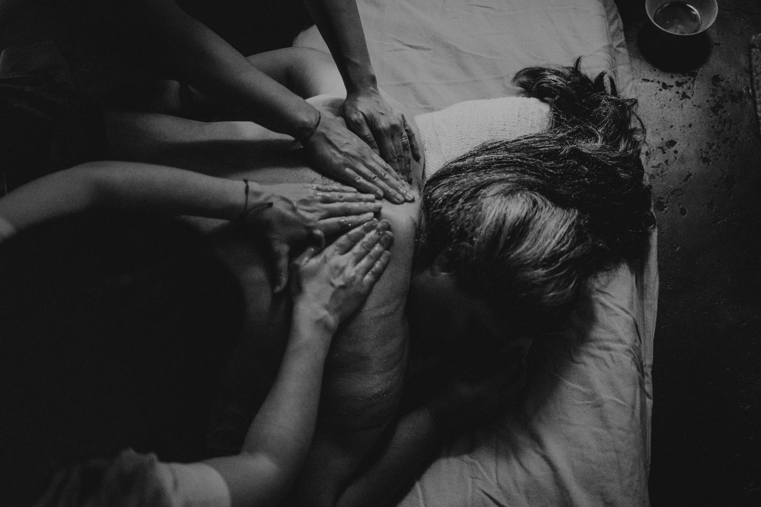 Foto preto e branco de Mulher recebendo massagem
em ritual fechamento dos ossos no Alentejo Portugal
