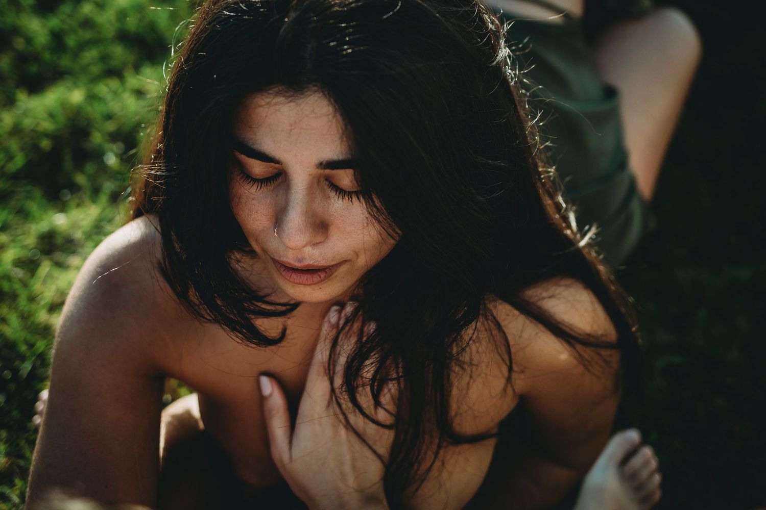 mulher jovem em um circulo feminino com uma mão no peito e olhos fechados em um circulo feminino em Portugal