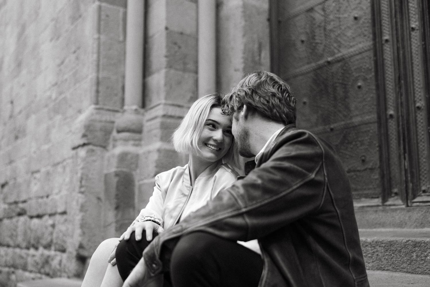 Black and white photos capturing intimate moments against stone architecture.