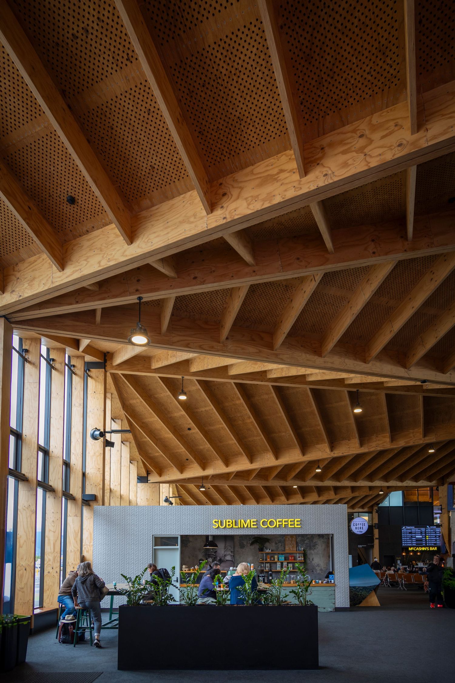 Interior shot of a coffee stall under large exposed timber rafters with natural light streaming in.