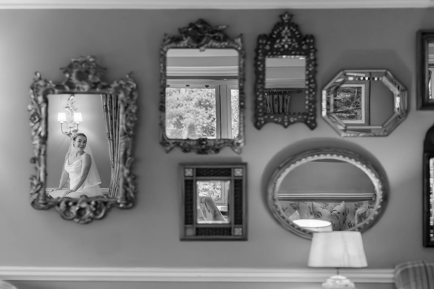 Ornate vintage frames display wedding photos on a grey wall.