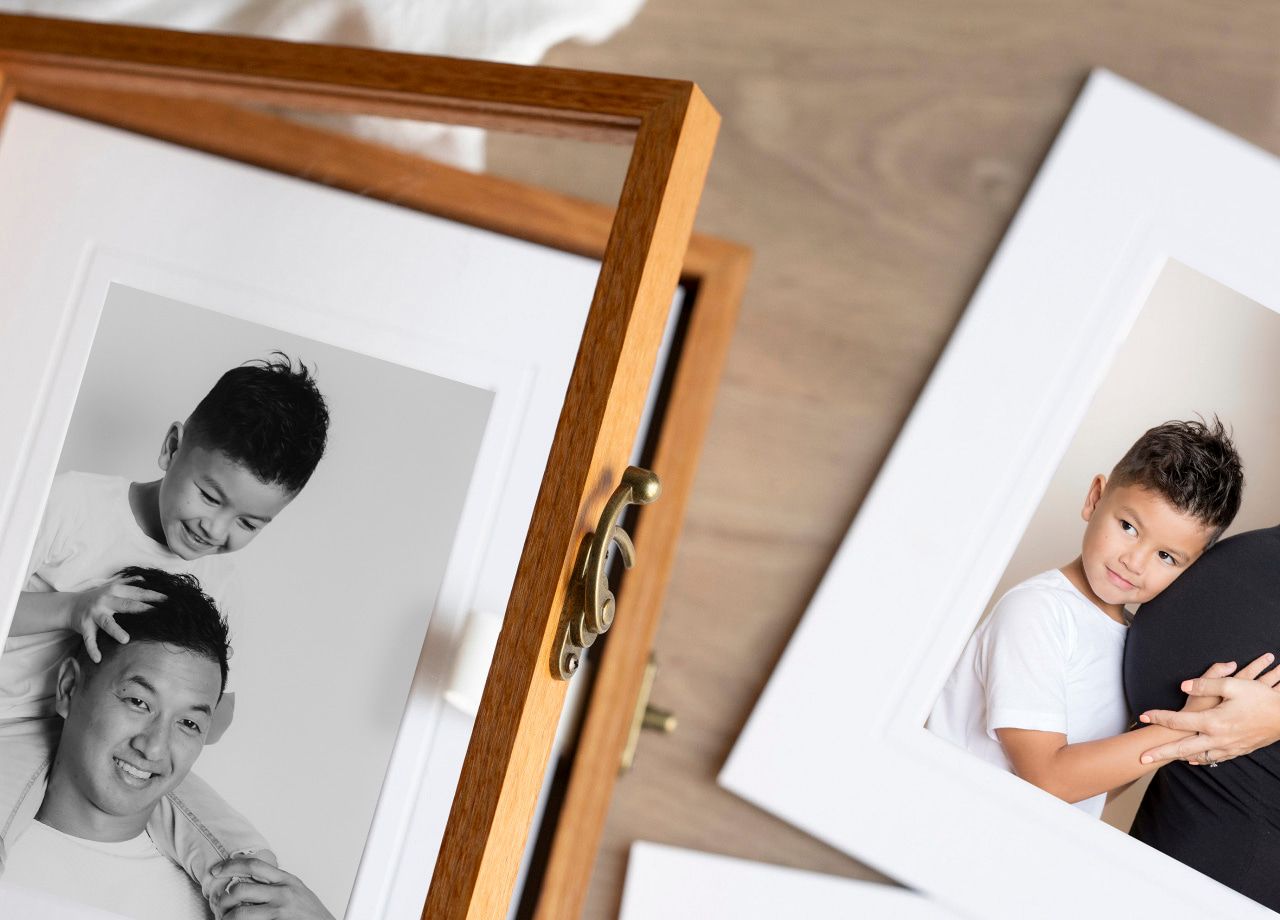 Wooden frame displaying black and white photographs on a wooden surface.