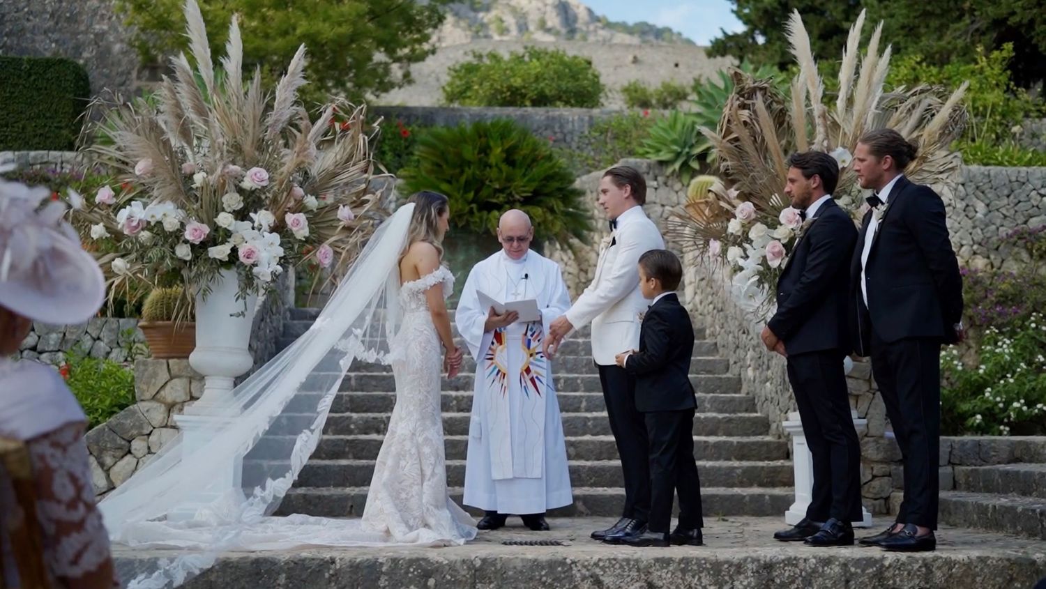 Bride and groom exchanging vows in an elegant outdoor ceremony, with emotional guests.