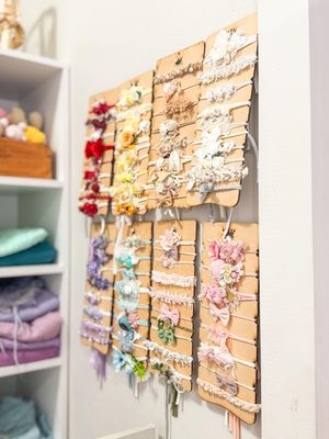 Wall display of colorful hair accessories arranged on cork boards in a neat organized pattern.