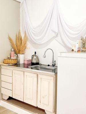 Modern white kitchen cabinets with light wood countertops and decorative wheat stalks for accent.