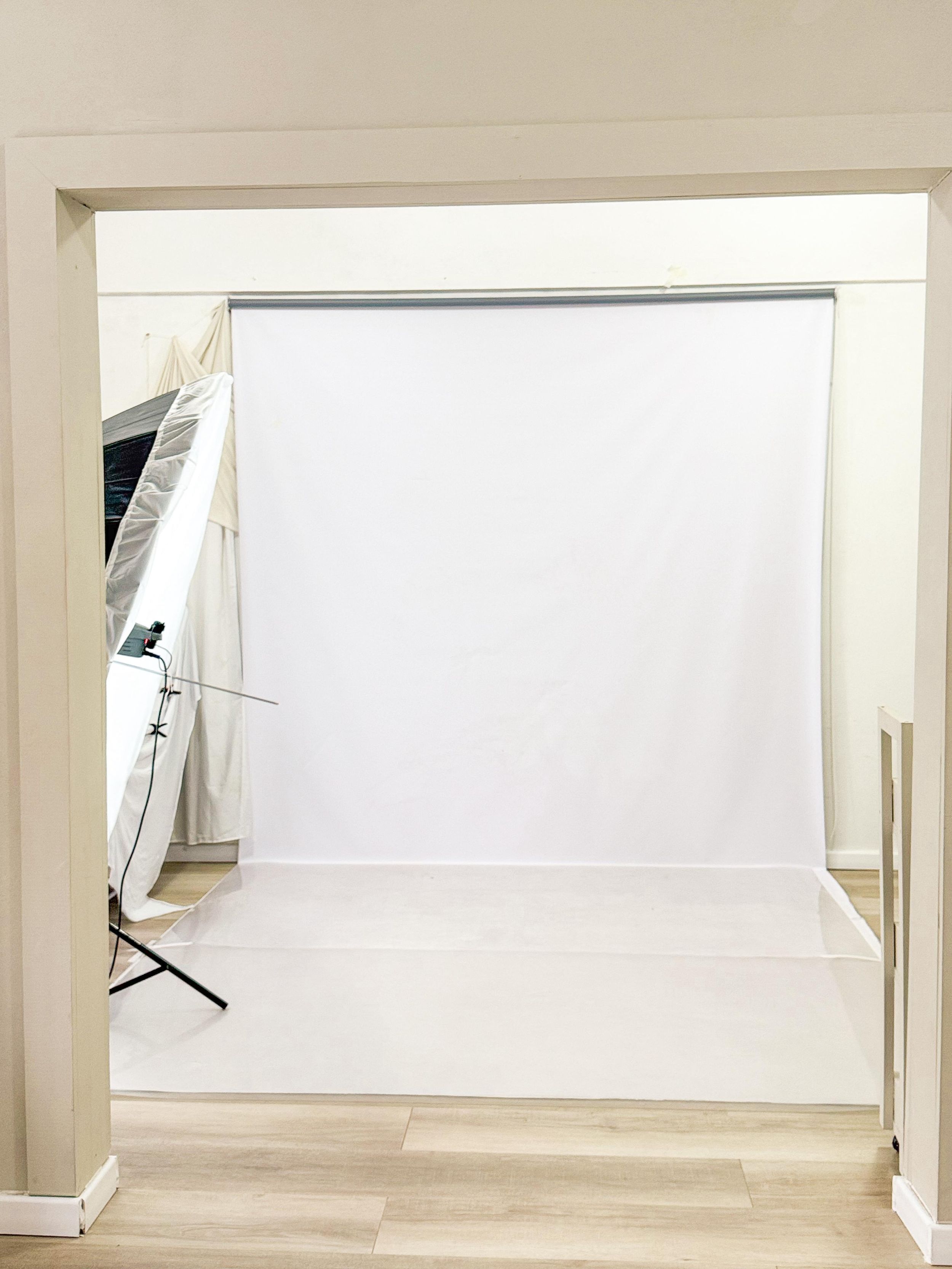 Studio setup with white photography backdrop and framing supports.