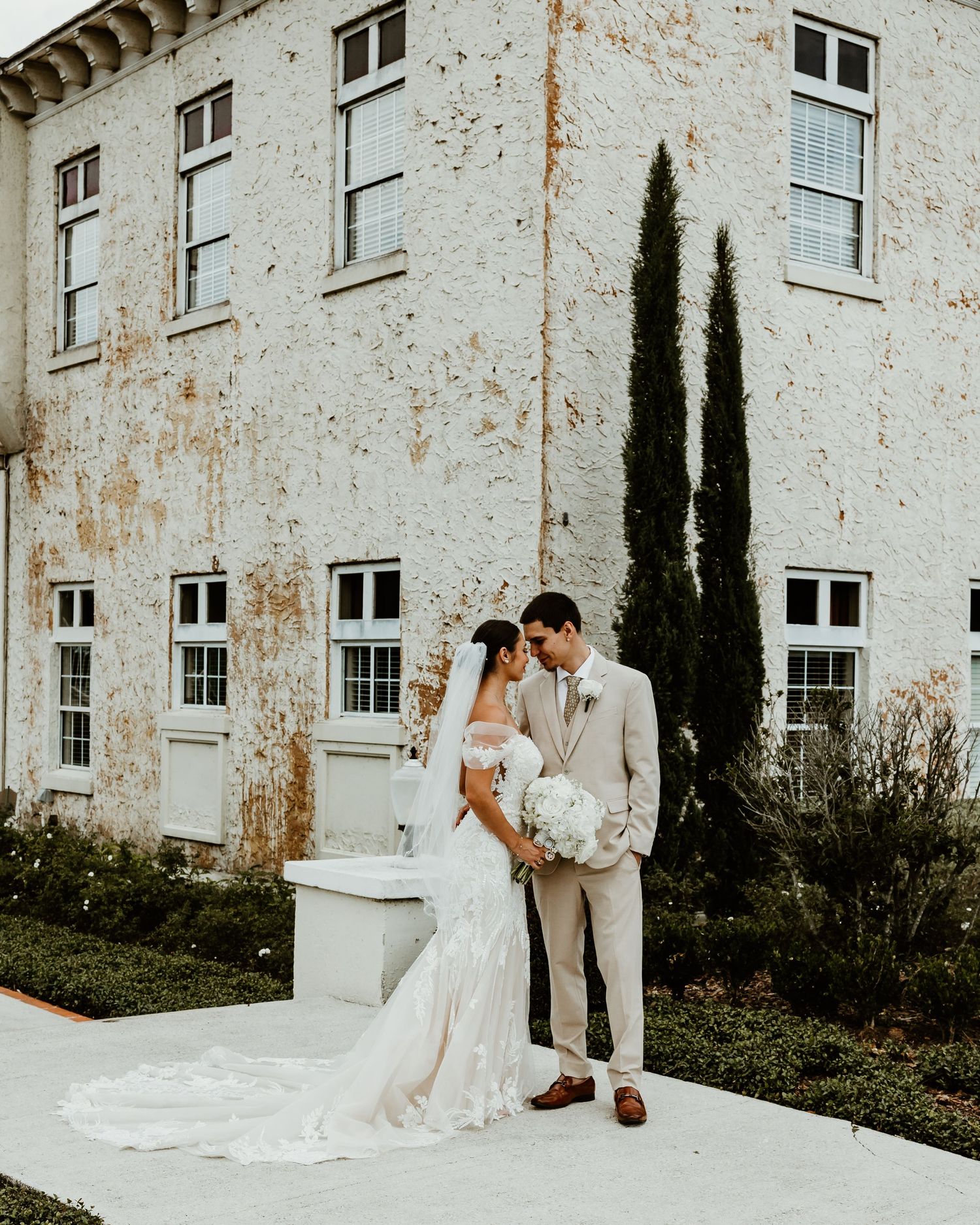 Tender moment between newlyweds illuminated by golden sunlight streaming through the window.