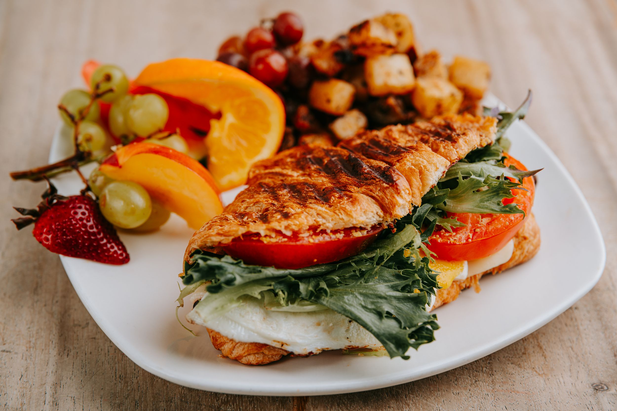A close-up sequence of plated grilled salmon with fresh vegetables and citrus garnish on white plates.