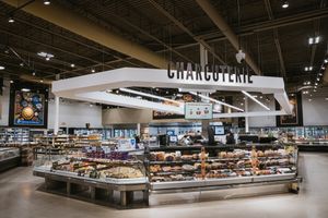 Large charcuterie counter display in modern grocery store.