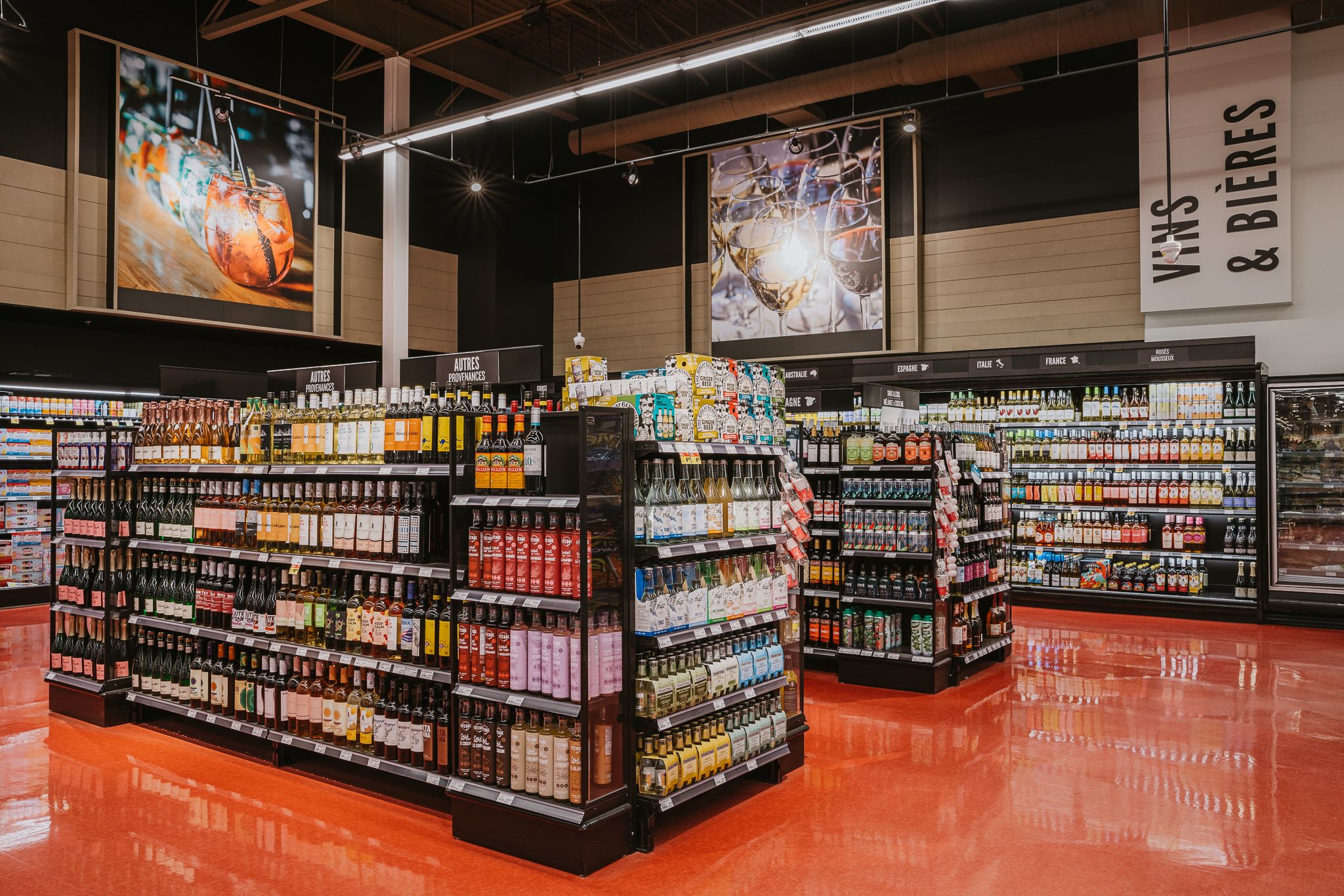 Interior of a retail store with neatly arranged aisles of products and colorful displays on red flooring.