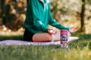 Canned beverage on grass during outdoor yoga or exercise session.