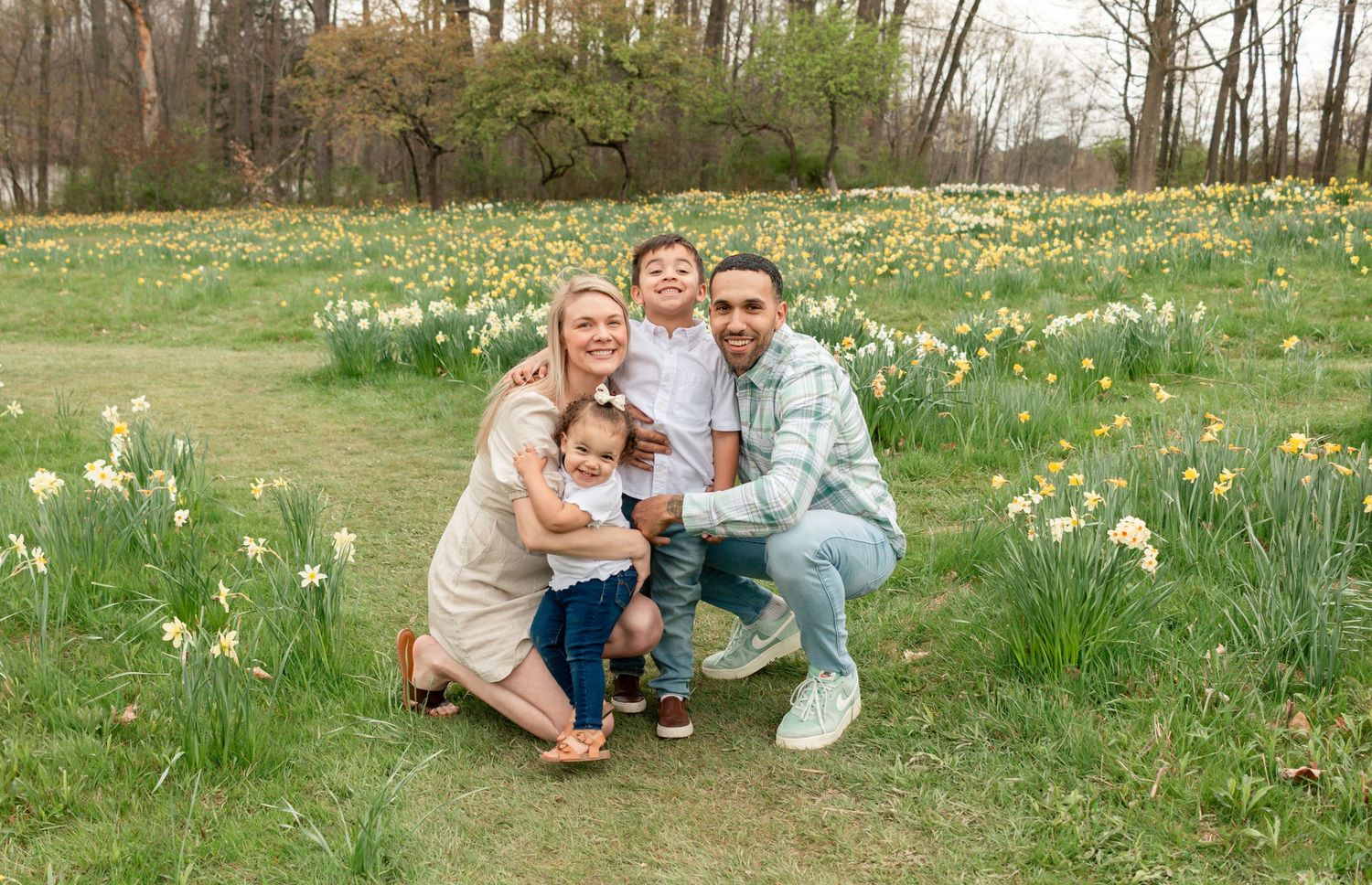 Family enjoying springtime in a meadow filled with blooming white daffodils on a sunny afternoon.Mill Creek Daffodhil Field, Youngstown, Ohi