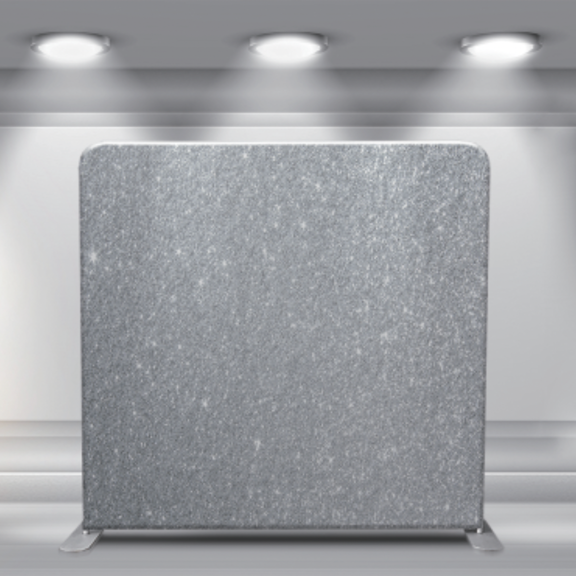 Silver sparkly backdrop display with overhead spotlights and smooth textured surface.
