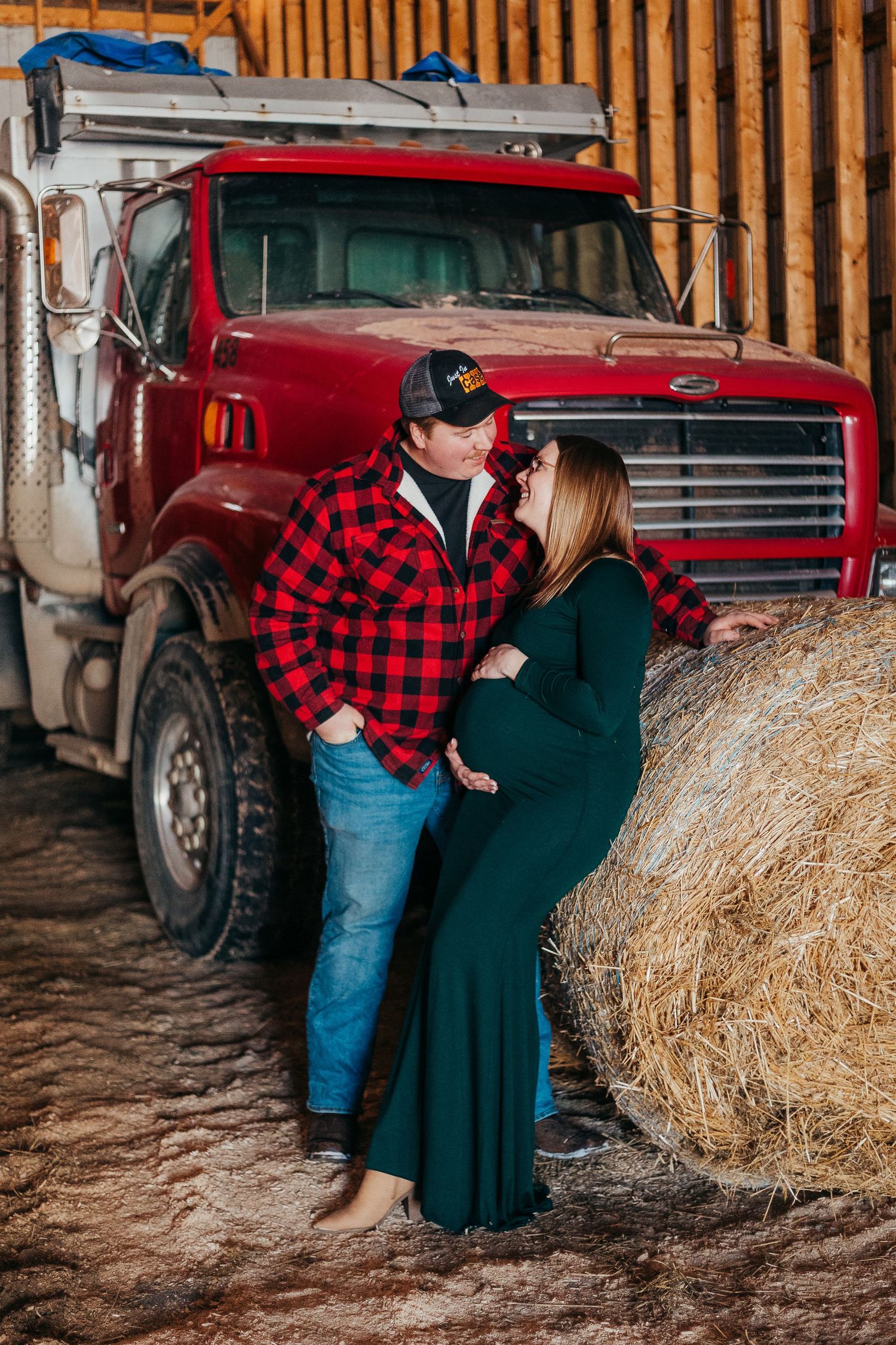 A rustic country scene with a red vintage truck and hay bales creates a cozy autumn setting along wooden barn walls.