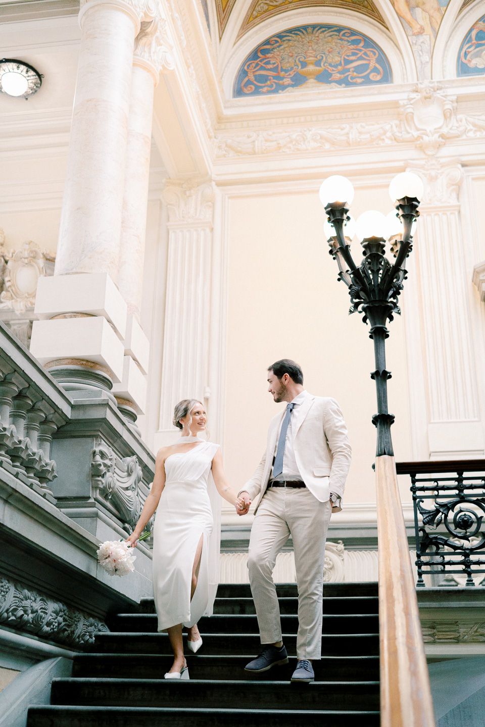 Bride and groom walking down the stairs of Montecatini Terme City Hall, Tuscany