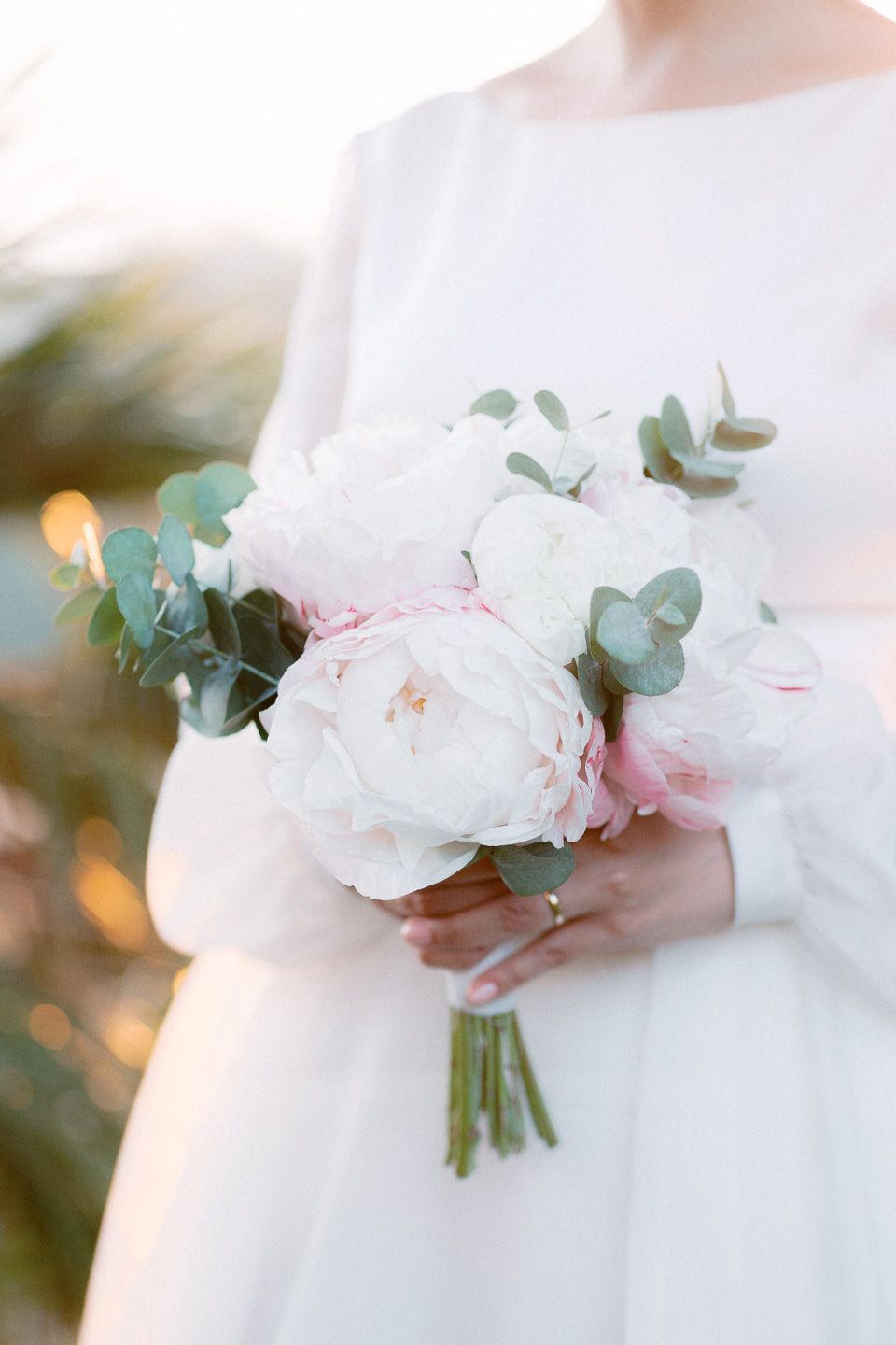 Bride holding her bouquet during her wedding photoshoot in Florence. The bouquet is made of pink peonies and soft green eucalyptus leaves.