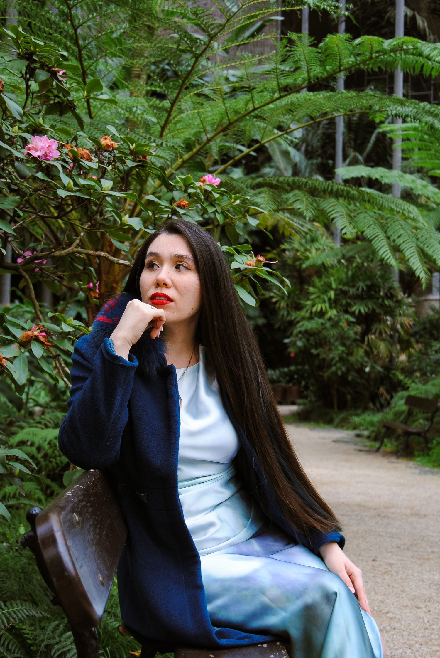 Woman sits on bench in garden