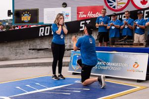 A marriage proposal taking place in front of a crowd at the st. john's, newfoundland's royal regatta with two people in blue clothing.