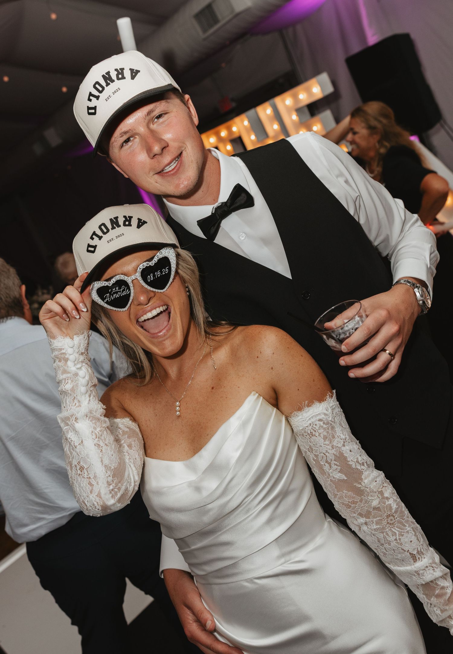 A series of party photos showing someone in a white wedding dress and baseball cap dancing and posing with sunglasses.