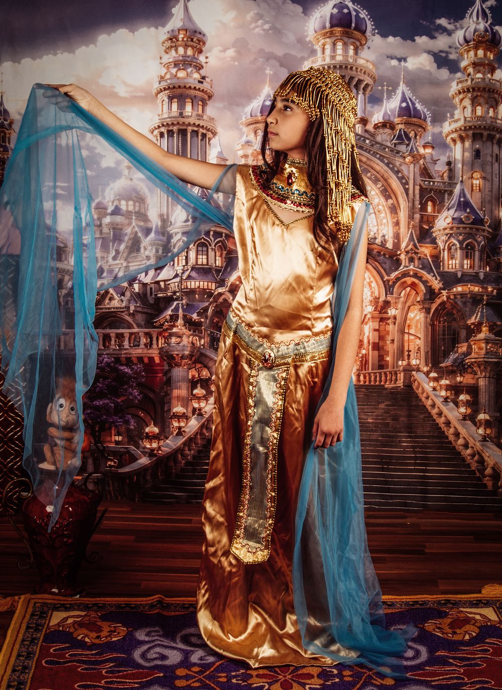 Fantasy cosplay photo series featuring ornate gold and blue costumes against a magical castle backdrop in dramatic lighting.