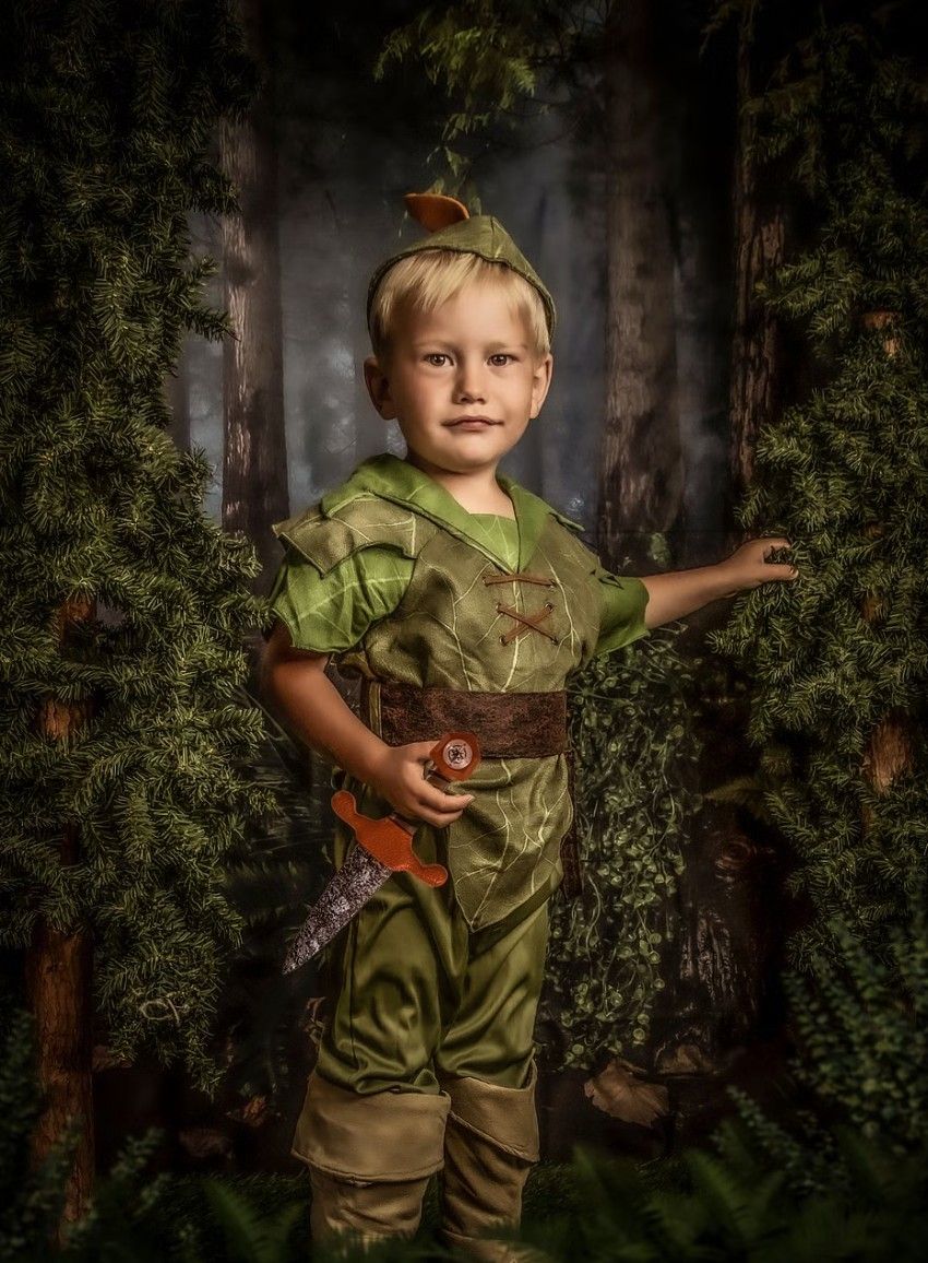 A Peter Pan inspired costume photography set in a mystical forest setting.