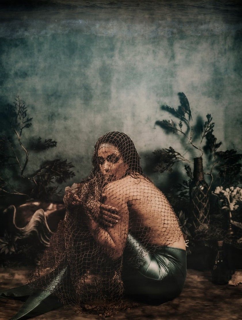 Dark and moody underwater photography with delicate lace textures and ethereal lighting effects.