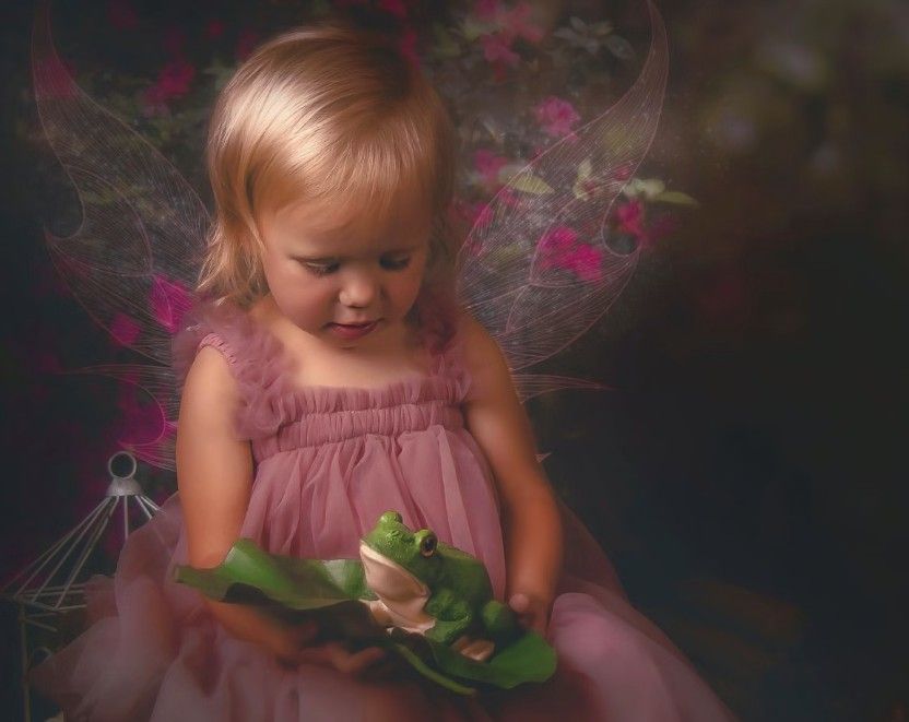 Child in dusty rose dress examining an object in a dreamy dark setting with pink accents.