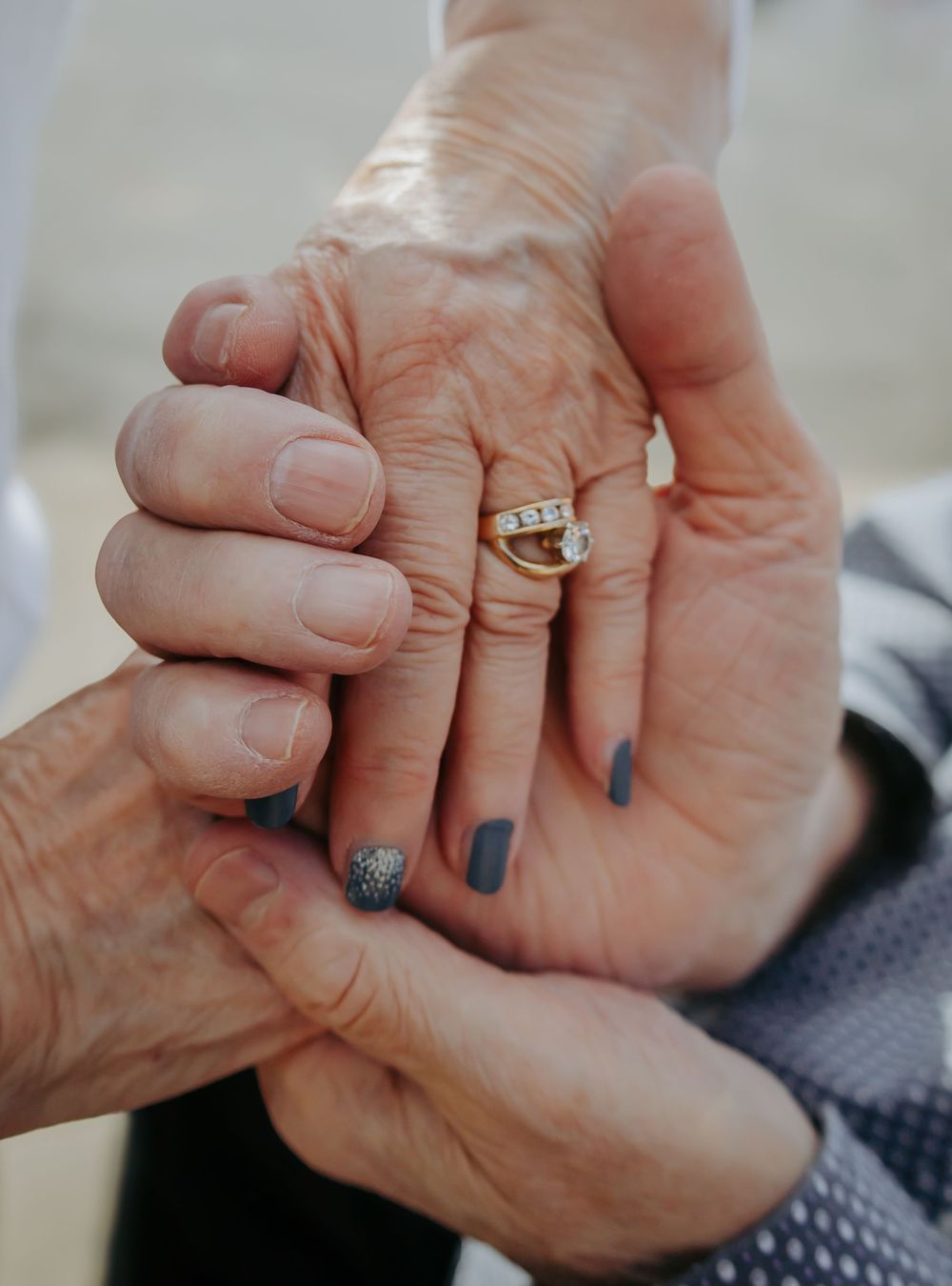 Close up of hands holding each other with rings showing love and commitment.