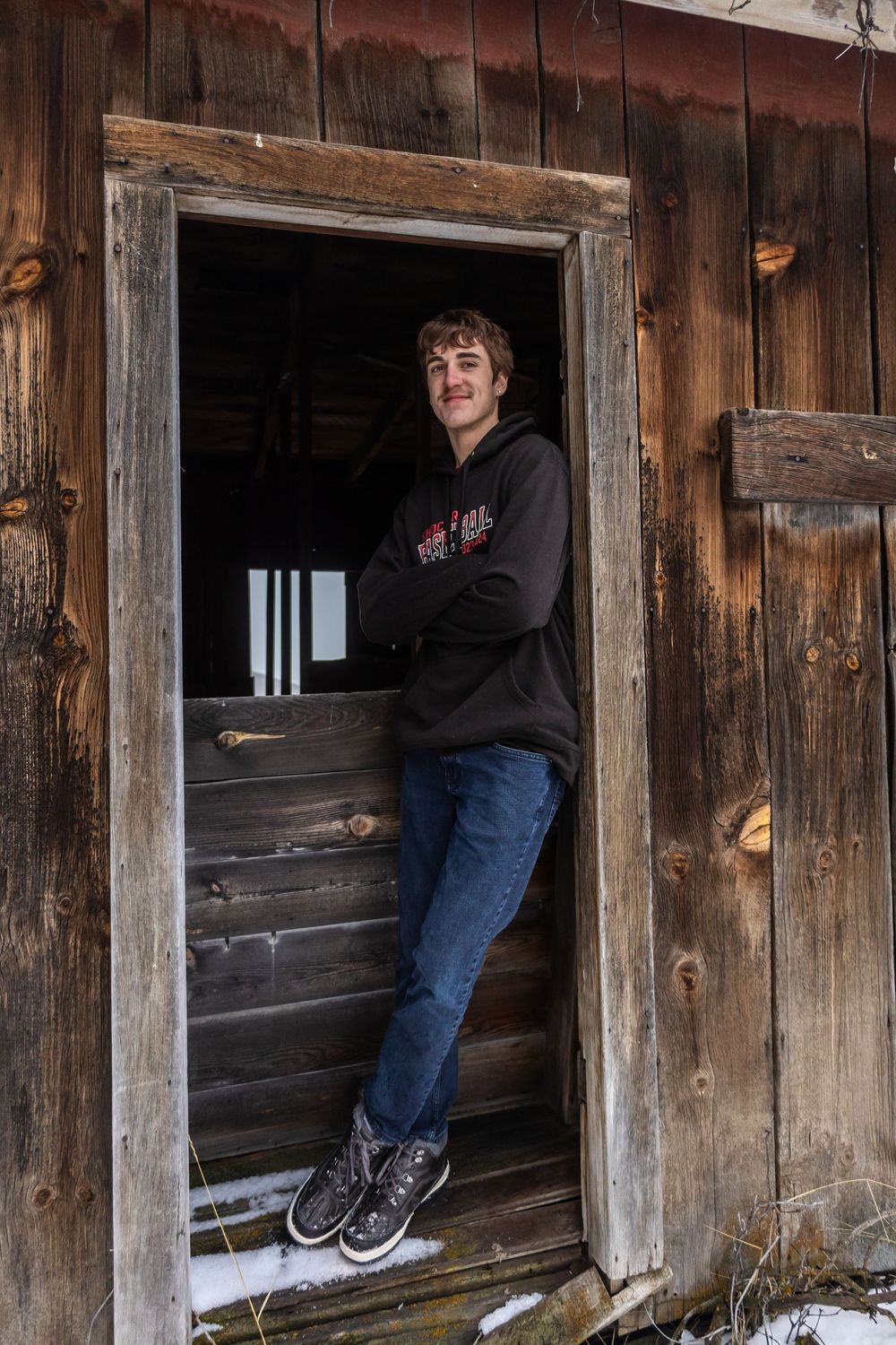A rustic wooden structure with weathered boards and open doorways in natural lighting.