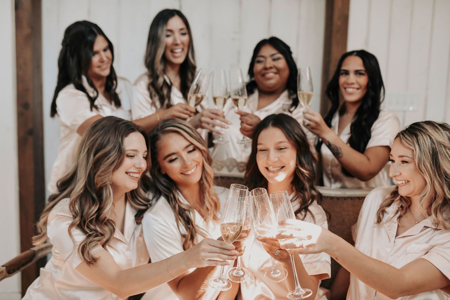Bride and bridesmaids popping champagne before the wedding in bridal suite